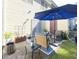Outdoor patio setup with table and chairs, shaded by a large blue umbrella, next to a green yard at 3831 Austin Park Ln, Decatur, GA 30032