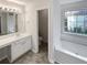 Bathroom featuring a vanity with sink, a soaking tub, and a separate toilet room for added privacy at 730 Taylor School Dr, Lawrenceville, GA 30043