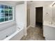 Bright bathroom features a soaking tub, a shower, and a vanity with a sink, offering a functional layout at 730 Taylor School Dr, Lawrenceville, GA 30043