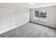 Bright bedroom with neutral carpet, a large window, and a door, creating a comfortable space at 730 Taylor School Dr, Lawrenceville, GA 30043