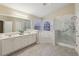 Bright bathroom featuring a large vanity with double sinks, tub, and a glass-enclosed shower at 1135 Chandler Ridge Dr, Lawrenceville, GA 30045