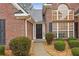 Inviting front entrance features a brick facade, complemented by lush greenery and decorative rock ground cover at 1135 Chandler Ridge Dr, Lawrenceville, GA 30045