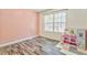 bedroom with a pink accent wall, wood flooring, and a large window for natural light at 171 W Fork Way, Temple, GA 30179