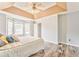 Light-filled bedroom featuring tray ceiling, ceiling fan, wood flooring, and double windows at 171 W Fork Way, Temple, GA 30179