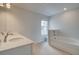 Bright bathroom featuring a soaking tub, white cabinetry, and a window for natural light at 312 Shine Dr, Stockbridge, GA 30281