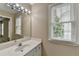 Bright bathroom features a white vanity with a marble countertop and a well-lit mirror at 5990 Somerset Ct, Suwanee, GA 30024