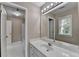 Bright bathroom with white cabinets, a large mirror, and access to a tiled shower and tub at 5990 Somerset Ct, Suwanee, GA 30024