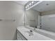 Well-lit bathroom with a large mirror, white cabinets, and a tiled shower and tub at 5990 Somerset Ct, Suwanee, GA 30024