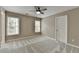 Inviting bedroom with neutral walls, soft carpet, a ceiling fan, and natural light from two windows at 5990 Somerset Ct, Suwanee, GA 30024