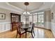 Formal dining room featuring hardwood floors, wainscoting, tray ceiling, and a chandelier at 5990 Somerset Ct, Suwanee, GA 30024