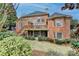 Rear exterior view of a brick home with wooden deck and backyard landscape at 5990 Somerset Ct, Suwanee, GA 30024