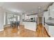 Open kitchen with hardwood floors, white cabinetry, black countertops and a dining area at 5990 Somerset Ct, Suwanee, GA 30024