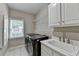 Functional laundry room with appliances, sink, and storage shelves at 5990 Somerset Ct, Suwanee, GA 30024