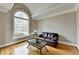 Bright living room with a large arched window, hardwood floors, and neutral paint at 5990 Somerset Ct, Suwanee, GA 30024