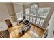 Open-concept living room with tall windows, hardwood floors, fireplace, and built-in shelving at 5990 Somerset Ct, Suwanee, GA 30024