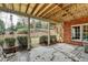 A covered patio includes a swing, brick wall and exposed rafters at 5990 Somerset Ct, Suwanee, GA 30024