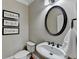 Charming powder room features an oval mirror, stylish fixtures, and decorative wall art at 5990 Somerset Ct, Suwanee, GA 30024