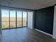 Open-concept living room with hardwood flooring, a large window, and a statement wall at 145 15Th St # Apt 1023, Atlanta, GA 30309