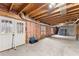 Unfinished basement with exposed beams, studded walls, and natural light from the double doors and windows at 4391 Chatuge Dr, Buford, GA 30519