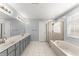 Modern bathroom with a double vanity, soaking tub, and a glass-enclosed shower at 4391 Chatuge Dr, Buford, GA 30519