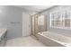 Bathroom with a tub shower combo, tile floors, and plenty of lighting and storage at 4391 Chatuge Dr, Buford, GA 30519