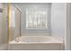 Bright bathroom featuring a soaking tub, shower, and gold fixtures at 4391 Chatuge Dr, Buford, GA 30519