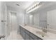 Bathroom with dual sinks, gray cabinets, large mirror, and multiple doors leading to separate areas at 4391 Chatuge Dr, Buford, GA 30519