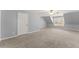 Light-filled bonus room showcasing sloped ceilings, neutral carpet, and a window with a view of the outdoors at 4391 Chatuge Dr, Buford, GA 30519