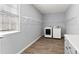 Well-lit laundry room with wood-look flooring, shelving and a window for natural light at 4391 Chatuge Dr, Buford, GA 30519