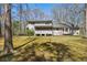 A view of the backyard with mature trees surrounding the home and a screened porch at 113 Bridget Dr, Hampton, GA 30228