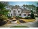 Elegant home featuring a circular driveway, stone water feature, and manicured landscaping at 2011 Palmetto Dunes Ct, Johns Creek, GA 30097