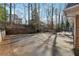 Large backyard featuring a paved driveway and wrought iron fence, surrounded by mature trees and landscaping at 3811 Harts Mill Ne Ln, Brookhaven, GA 30319