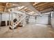 Spacious unfinished basement with a concrete floor, cinderblock walls, and a white staircase at 3811 Harts Mill Ne Ln, Brookhaven, GA 30319