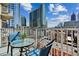Balcony seating offers panoramic city view with high-rise buildings and blue skies with fluffy clouds at 860 Peachtree Ne St # 1008, Atlanta, GA 30308