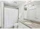 Well-lit bathroom featuring a granite countertop vanity, a white shower curtain, and modern fixtures at 860 Peachtree Ne St # 1008, Atlanta, GA 30308