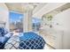 Bright bedroom featuring a large window with city views, complemented by a patterned comforter and stylish furniture at 860 Peachtree Ne St # 1008, Atlanta, GA 30308
