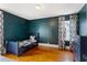 Dark teal bedroom with hardwood floors, a daybed, modern curtains and natural light at 1721 Clifton Se Way, Atlanta, GA 30316