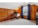 Well-lit bedroom showcasing natural wood paneling, plush carpet, and a large window with blinds at 1721 Clifton Se Way, Atlanta, GA 30316