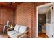 Cozy enclosed porch featuring brick walls, cushioned seating, and plenty of natural light at 1721 Clifton Se Way, Atlanta, GA 30316