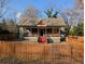 Exterior view of a fenced home featuring a covered porch with traditional design and mature trees at 3124 Usher Nw St, Covington, GA 30014