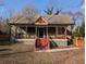 Charming home featuring a covered front porch with decorative wooden supports and red stairs leading to the front door at 3124 Usher Nw St, Covington, GA 30014