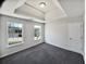 Bedroom with a tray ceiling, two windows, and plush gray carpet at 4906 Laythan Jace Ct, Snellville, GA 30039