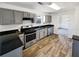 Well-lit kitchen with granite counters, stainless steel appliances, and wood flooring at 4906 Laythan Jace Ct, Snellville, GA 30039