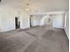 Large carpeted living room featuring neutral walls, an elegant light fixture, and two doors at 4906 Laythan Jace Ct, Snellville, GA 30039