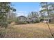 Back exterior view of home with deck and stairs surrounded by mature trees and dry lawn at 185 Nickajack Se Rd, Mableton, GA 30126