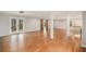 Open basement area with hardwood flooring, white support beams, and double doors to the backyard at 185 Nickajack Se Rd, Mableton, GA 30126