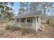 Exterior of a cottage featuring a covered porch, white railings, and gray siding at 185 Nickajack Se Rd, Mableton, GA 30126