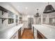 Bright kitchen boasts stainless appliances, white cabinets, farmhouse sink, and an island with a stone counter at 185 Nickajack Se Rd, Mableton, GA 30126