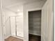 Bathroom offers tiled walk-in shower with glass doors and shelving in closet at 2371 Brown Dove Way Lot 4, Grayson, GA 30017