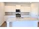Modern kitchen with white cabinets, granite countertops, and stainless steel appliances at 2371 Brown Dove Way Lot 4, Grayson, GA 30017